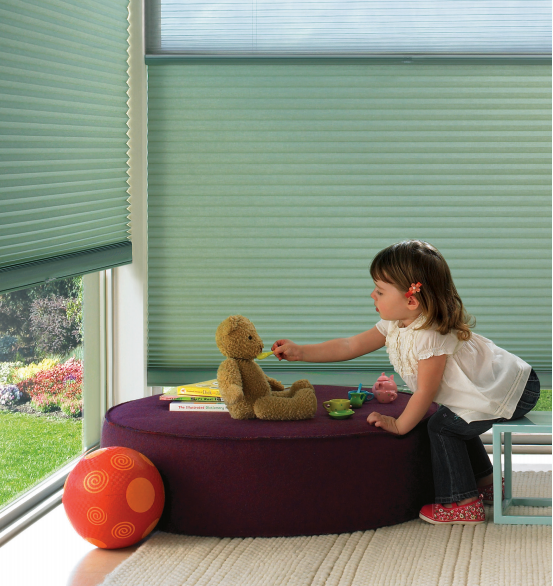 little girl playing in room with soft green Hunter Douglas Duette window treatments