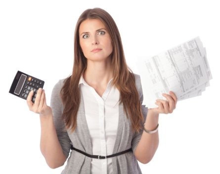 woman frustrated holding calculator and energy bills